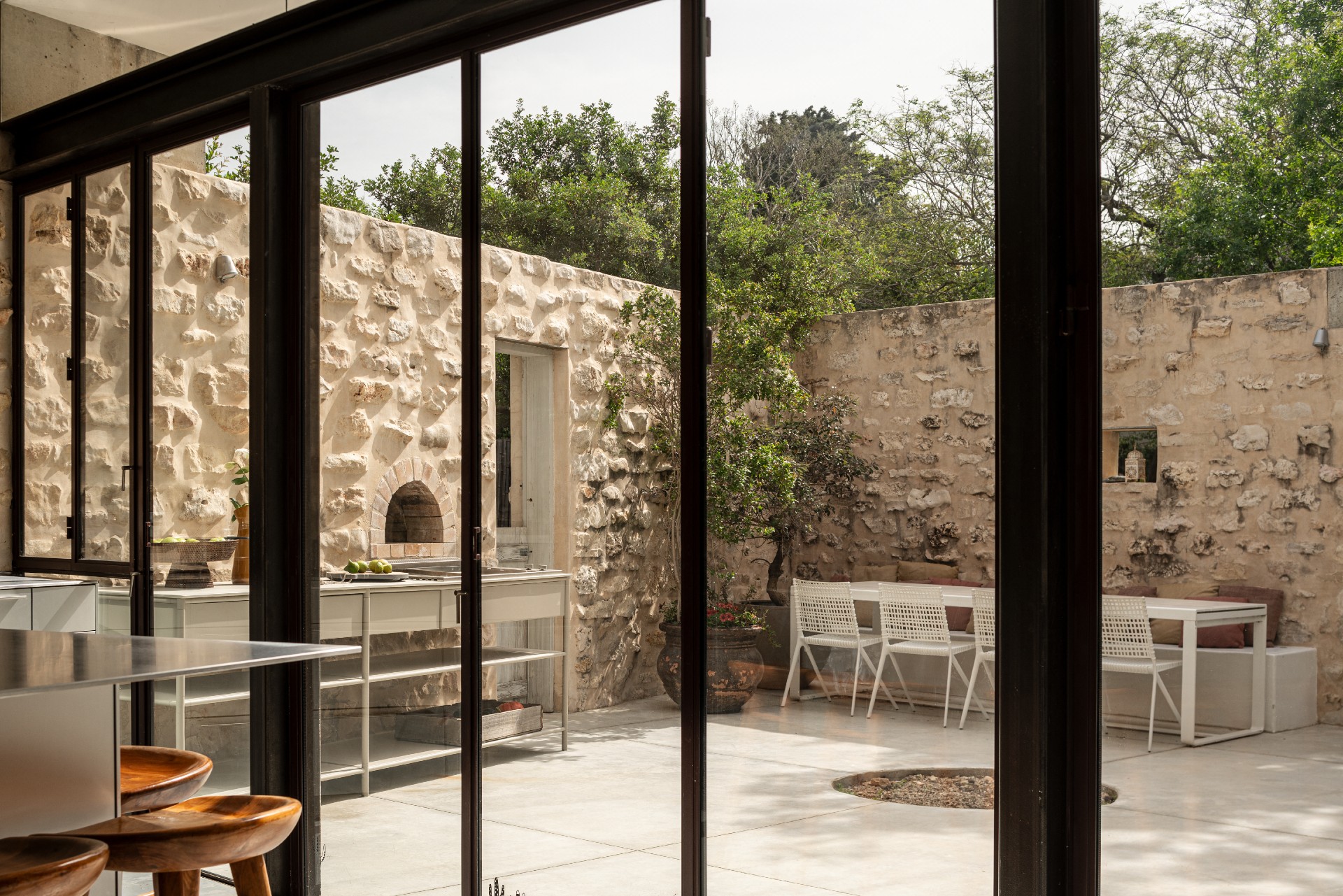 CSL open-concept outdoor kitchen with wooden stools