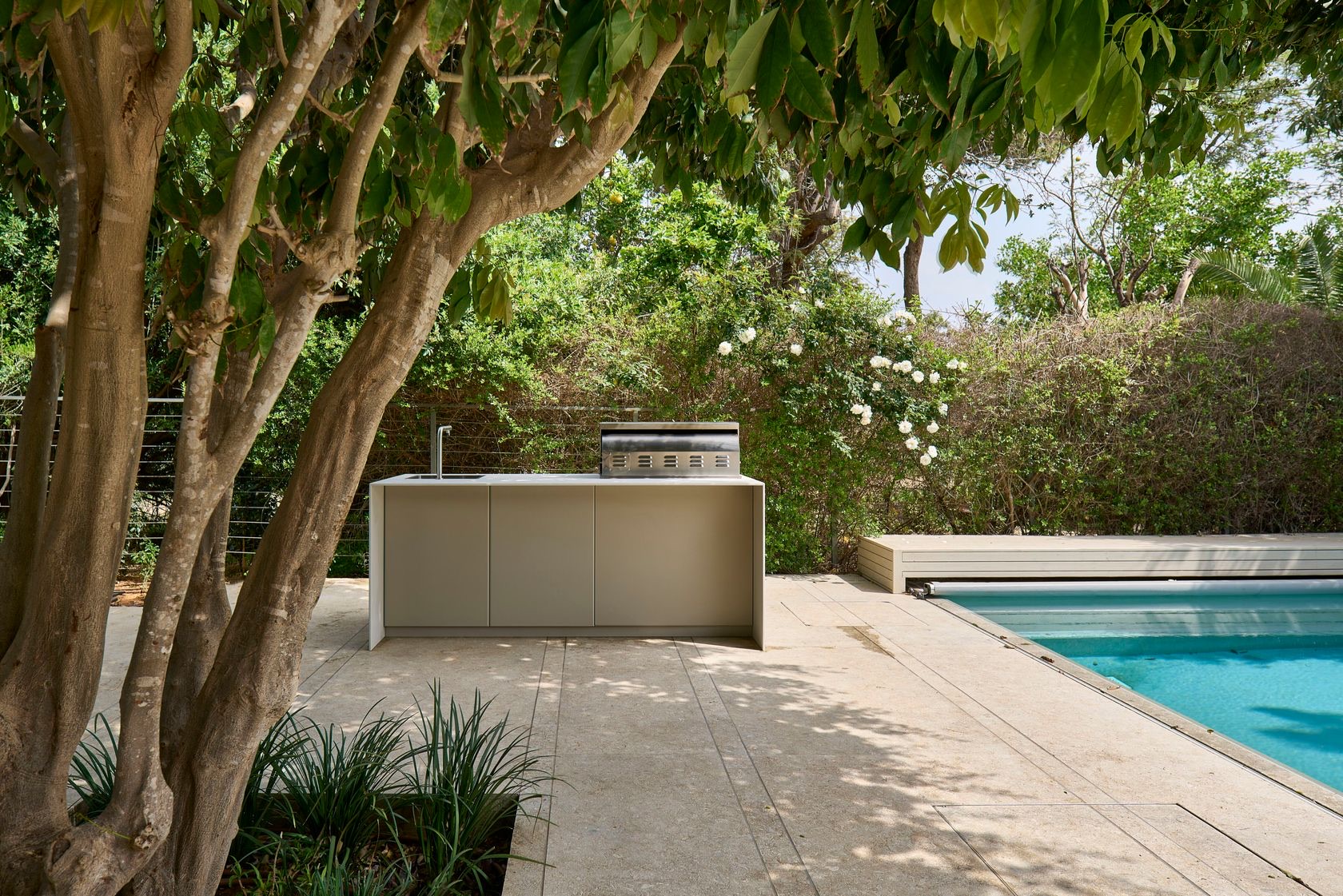 UNICA 210 in a garden beside a pool and olive tree