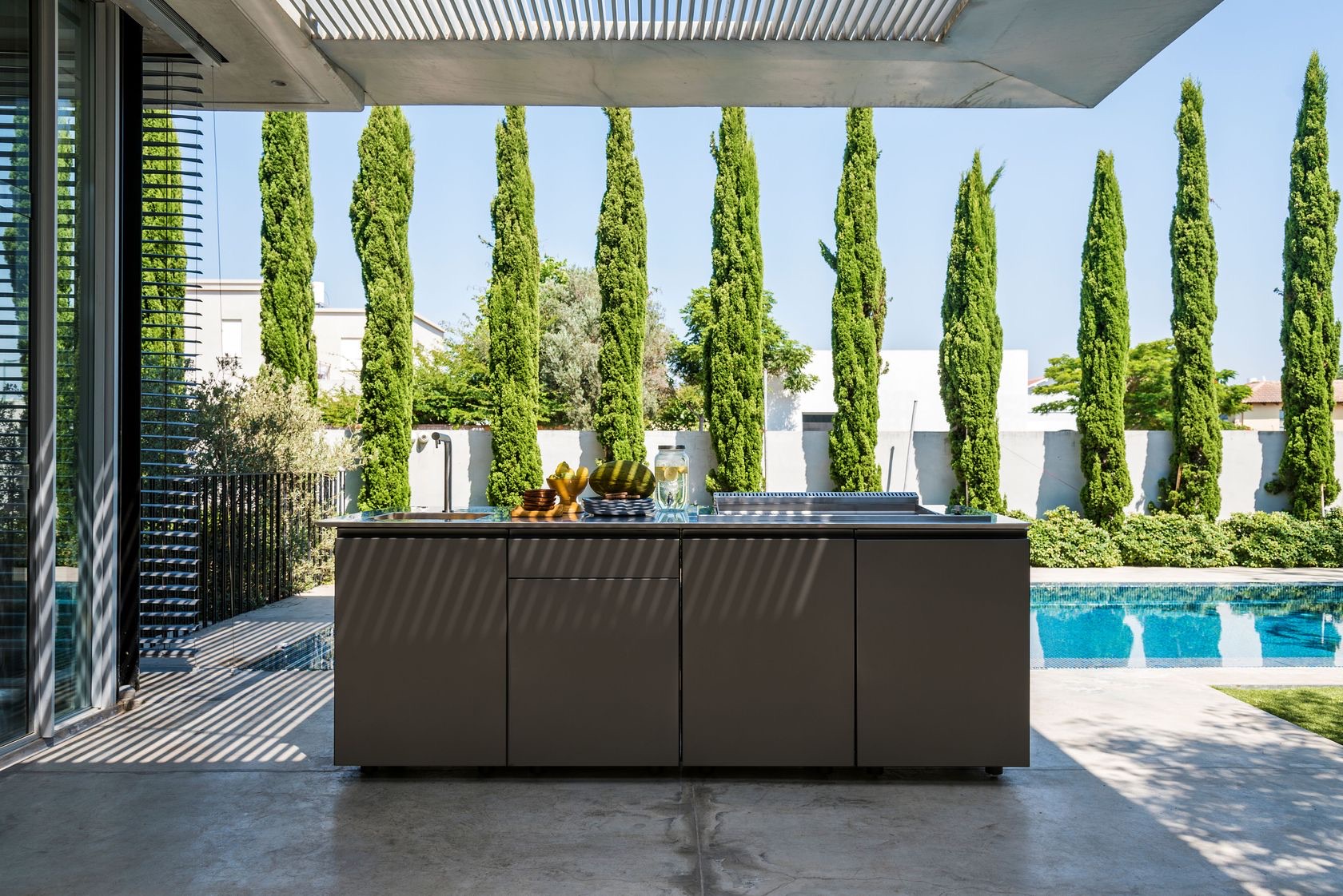 UNICA 240 dark island against cypress trees in pergola shadow