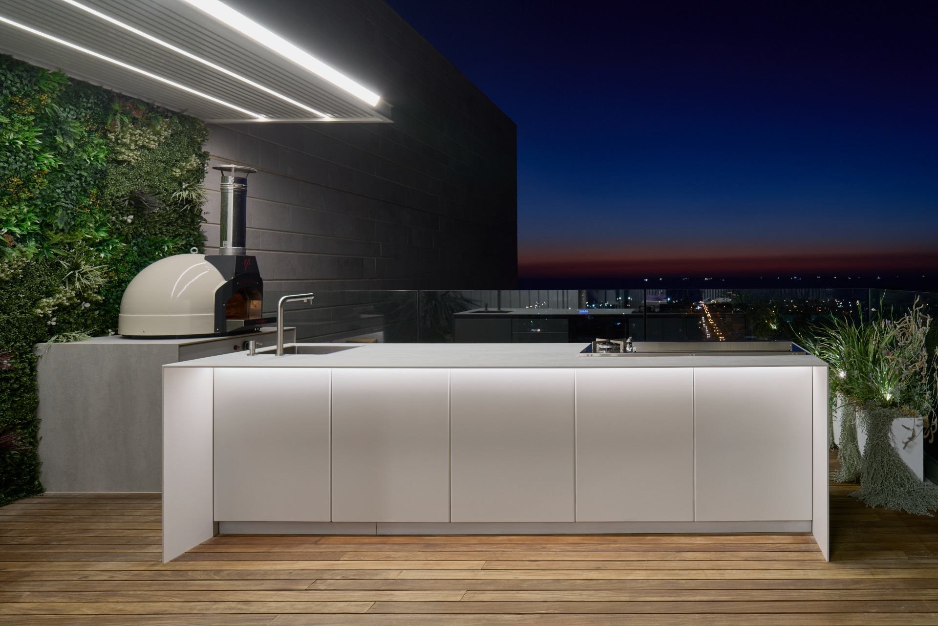 White UNICA island at dusk with pizza oven